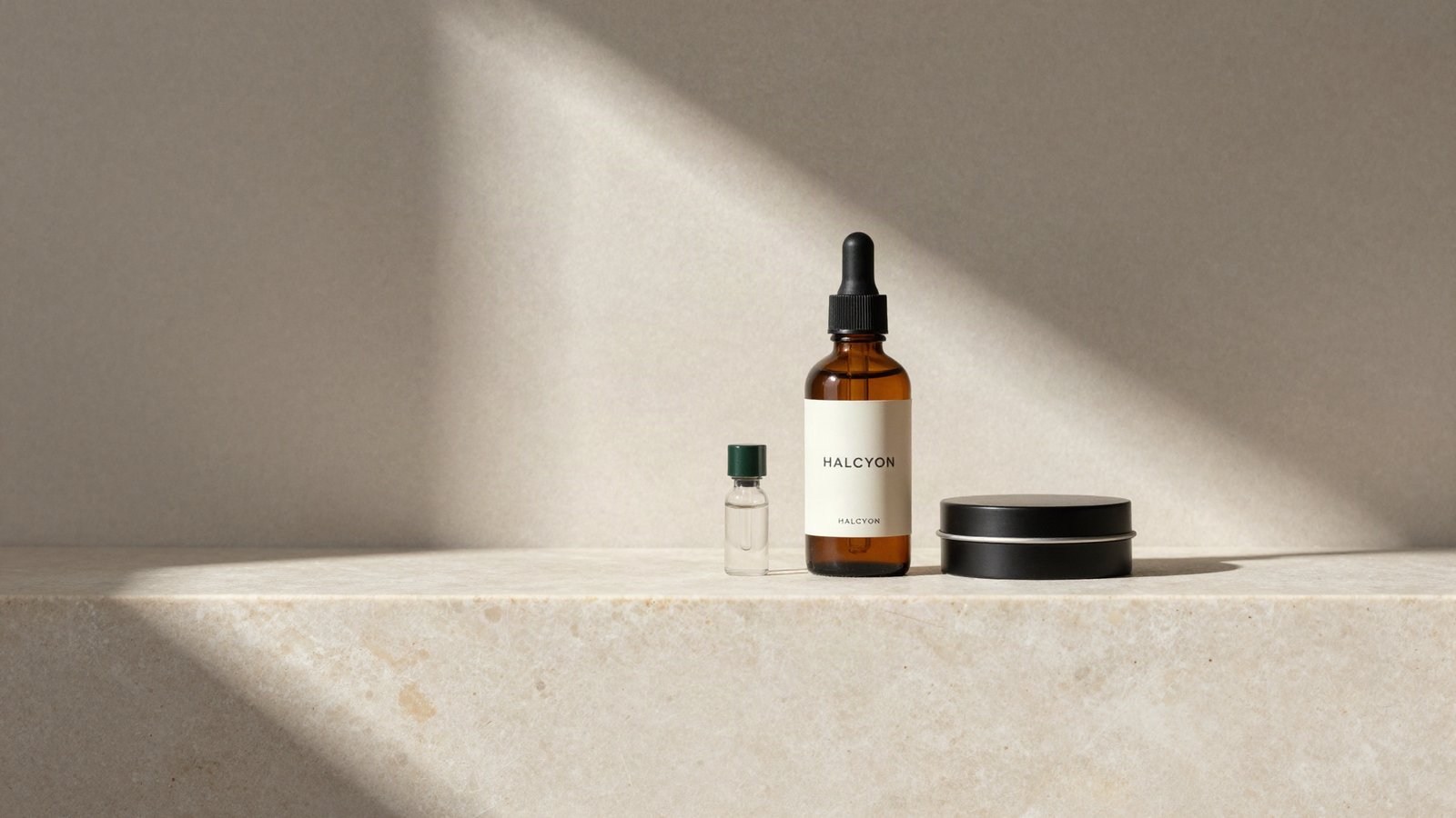 Halcyon dropper bottle, tin and vial on a travertine ledge in soft daylight